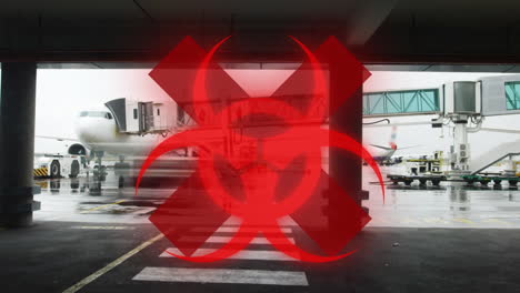 hazard and red cross sign against airport runaway in background