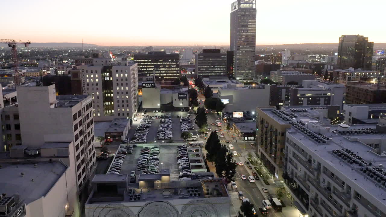 Aerial view of a bustling city at dusk with illuminated streets and buildings