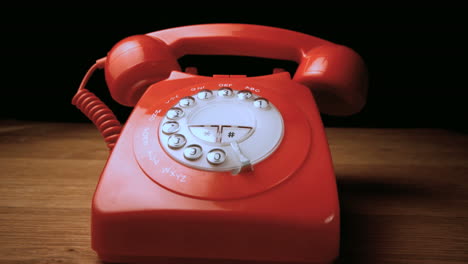 Red-receiver-falling-onto-retro-dial-phone