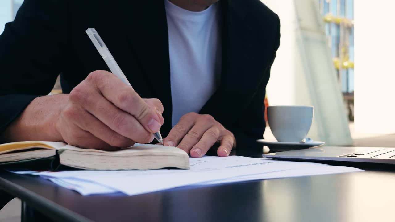 Una persona che scrive su un taccuino mentre lavora