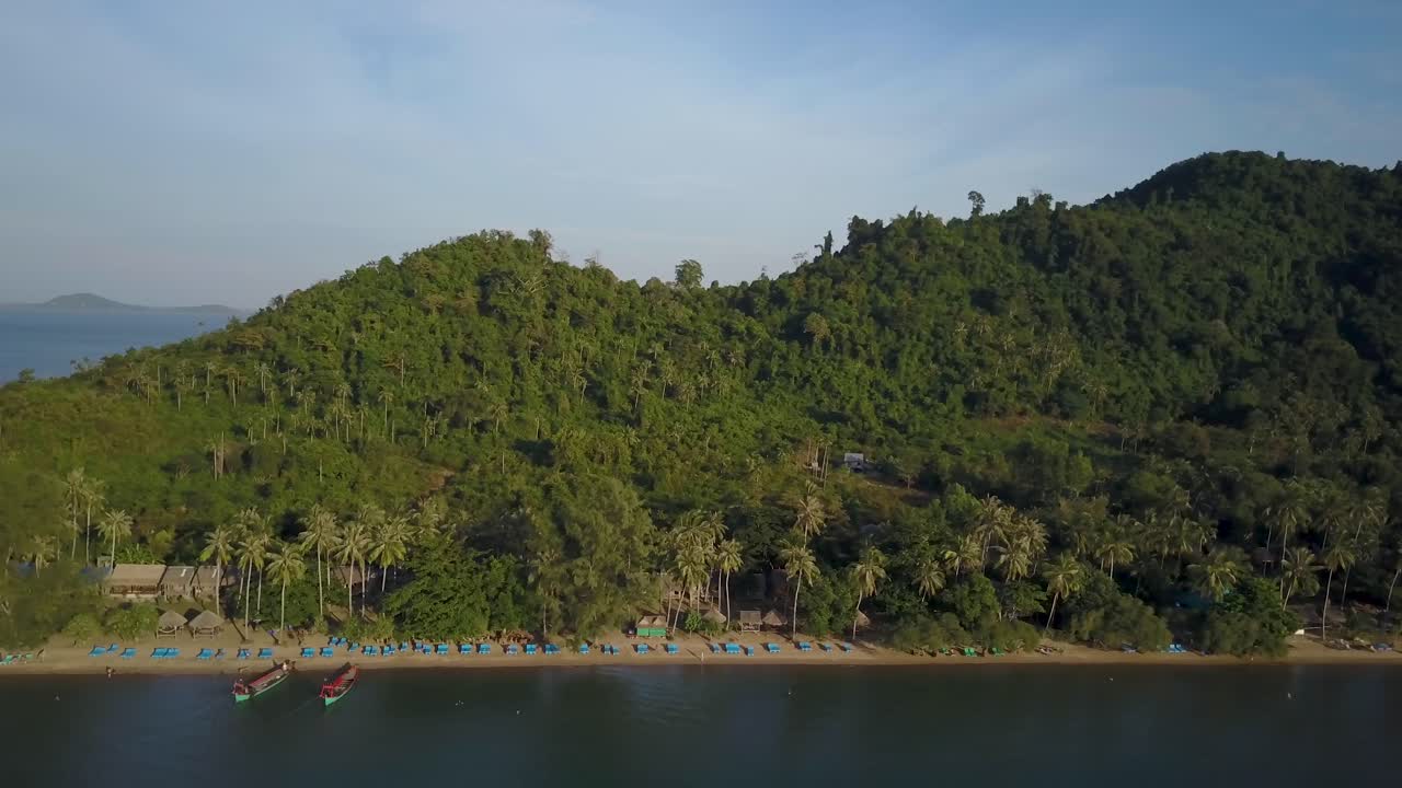 Aerial view of a tropical beach with lush vegetation and boats