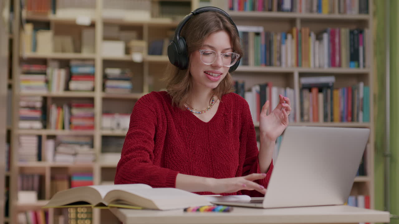Young woman listening to audio using headphones in library