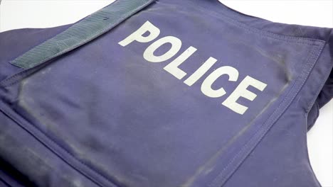 black firearm hand pistol placed on top of a police bullet proof safety vest