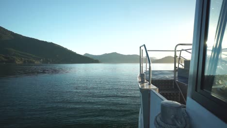 slowmo - morning sunrise boat ride in marlborough sounds, new zealand with mountains in background