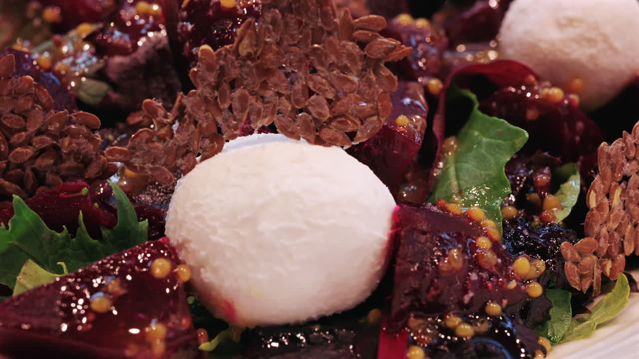 Primo piano di un'insalata di barbabietole con formaggio cremoso, semi e foglie verdi