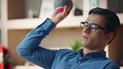 un hombre de negocios de primer plano lanzando la pelota en la oficina. un freelance relajado tomando un descanso del trabajo.