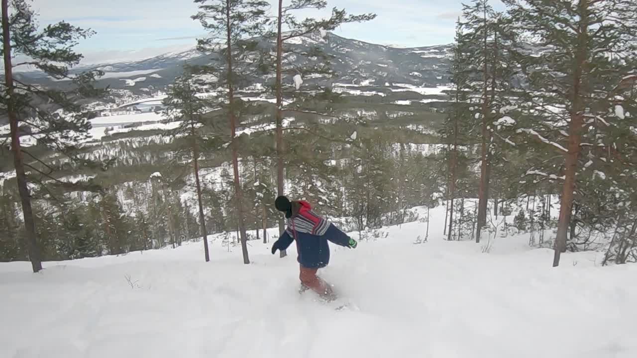 snowboarder rides offpistt powder down the mountain in forest - Slow motion