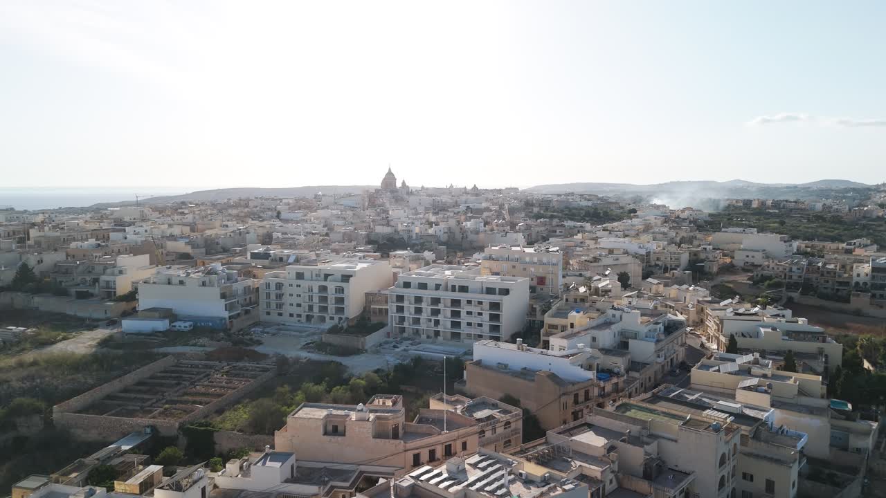 Ripresa aerea con drone di case sull'isola di Gozo, Malta, filmato 4K 60FPS in stile cinematografico che mostra la tradizionale architettura in pietra calcarea, i tetti dei villaggi e il paesaggio costiero mediterraneo