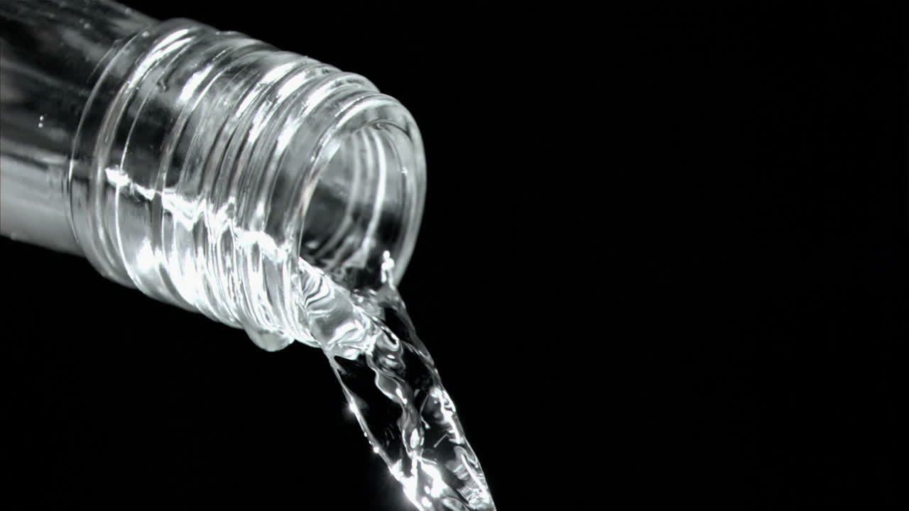 goteo de agua en una cámara súper lenta que fluye del cuello de botella de vidrio