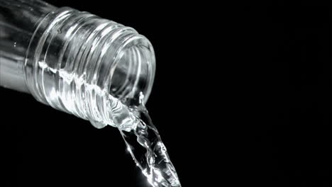 trickle of water in a super slow motion flowing of the glass bottleneck