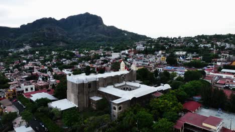 Aerial-view-around-the-Parroquia-Nuestra-Señora-de-la-Natividad-in-Tepoztlan,-Morelos,-cloudy-Mexico