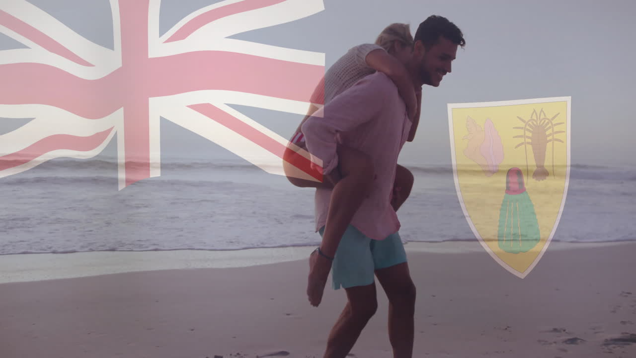 caminando por la playa, pareja sosteniendo la bandera británica y el escudo de armas de turks y caicos