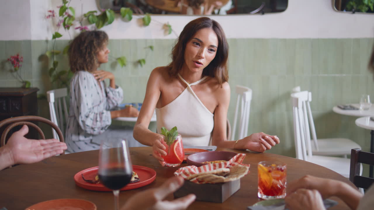 mujer lujosa bebiendo cócteles en una cafetería de primer plano. dama feliz hablando amigos