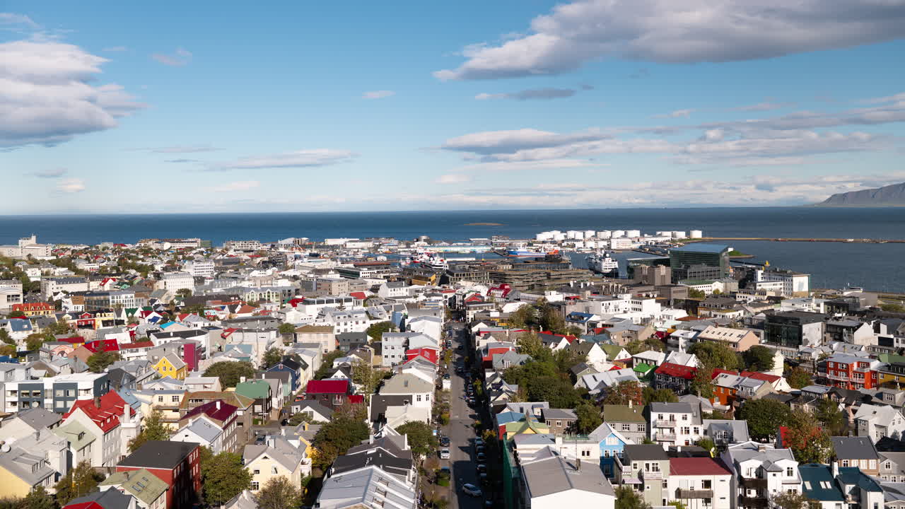 Selang waktu kaki langit pusat kota Reykjavik, Islandia, dengan atap warna-warni yang membentang ke laut