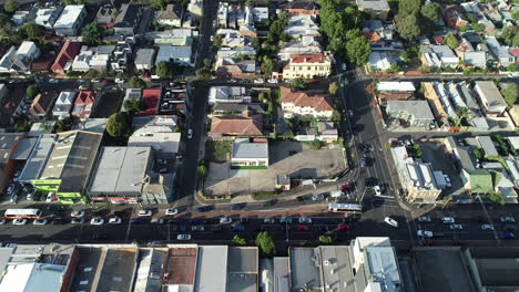 Static-aerial-perspective-of-traffic-moving-through-inner-city-intersection-during-morning-peak-hour-traffic