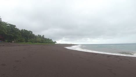 storm-on-a-black-sandy-tropical-beach-with-an-overcast-sky-as-the-wind-blows-palm-trees-no-people-the-Philippines-4k