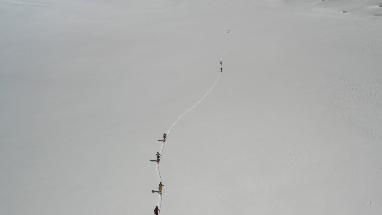 빙하를 오르는 스키 선수들의 4k 드론 영상