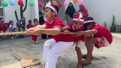 children enthusiastically participate in the tug of war or tarik tambang during the indonesian independence day