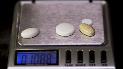 weighing pills on digital scale