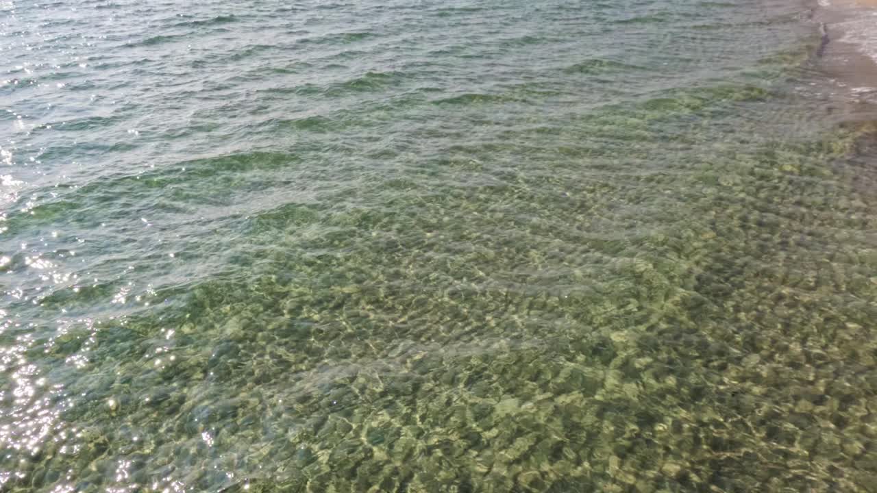 부드러운 파도가 모래 해안선을 따라 물결을 일으니다.