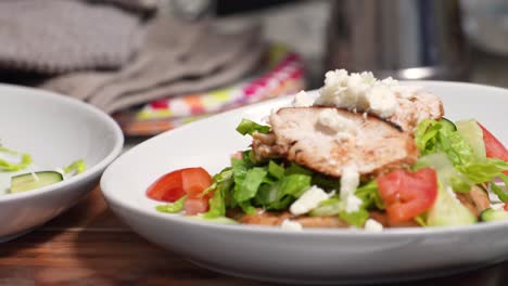 ready to serve fresh vegetable salad with pita bread and topped with roasted chicken. - closeup shot