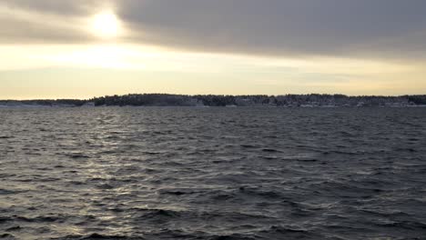 Wave-with-sunset-and-forest,-village-in-the-distance