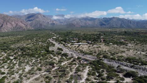 Flyover-dry-rocky-riverbed-in-mountain-plateau-in-Cafayate,-Argentina