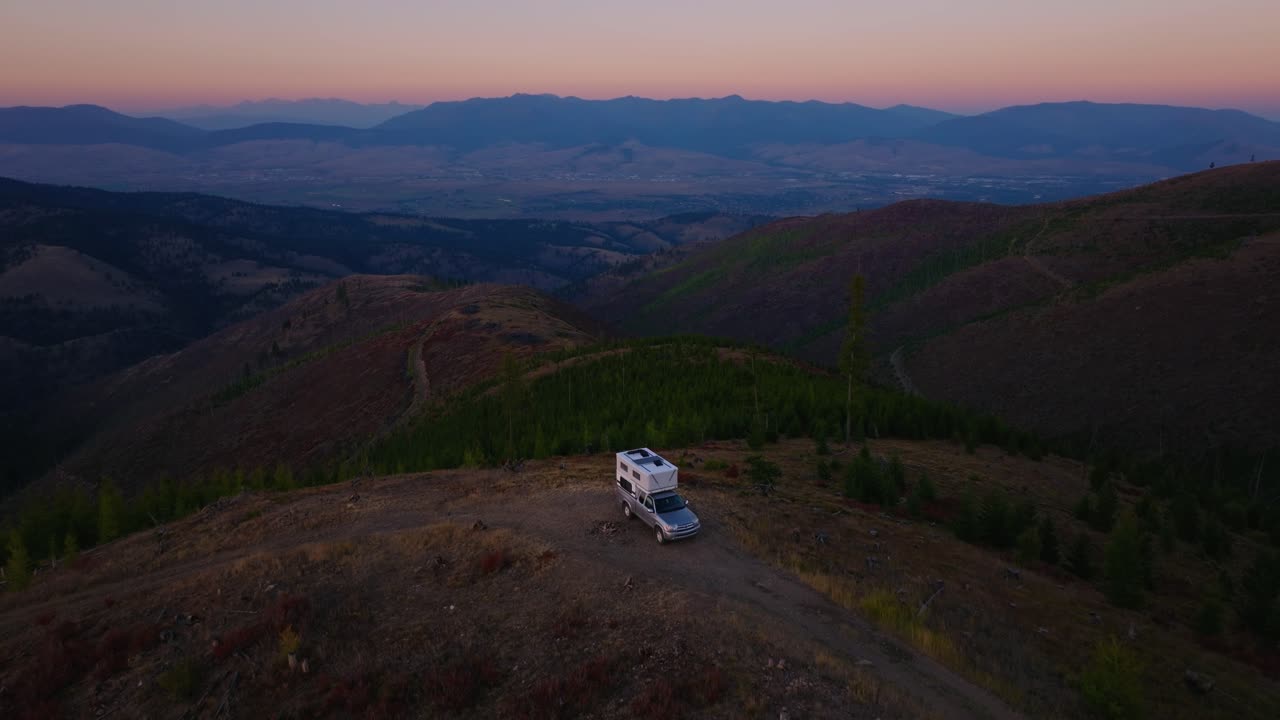 Camper al crepuscolo con vista sulle montagne di Missoula, Montana, ripresa aerea con allontanamento.