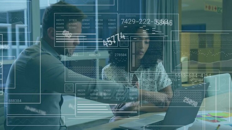 Showing smartphone, woman polka-dot blouse, man grey shirt reviewing charts on laptop at office HUD