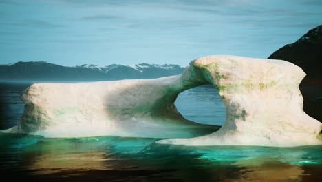 a large iceberg with an arch formation in the arctic