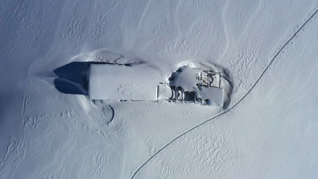 vista aérea mirando hacia un cobertizo de montaña cubierto de nieve - granero mientras se eleva lentamente