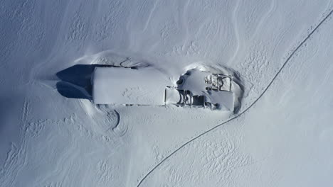 Vista-Aérea-Mirando-Hacia-Un-Cobertizo-De-Montaña-Cubierto-De-Nieve---Granero-Mientras-Se-Eleva-Lentamente