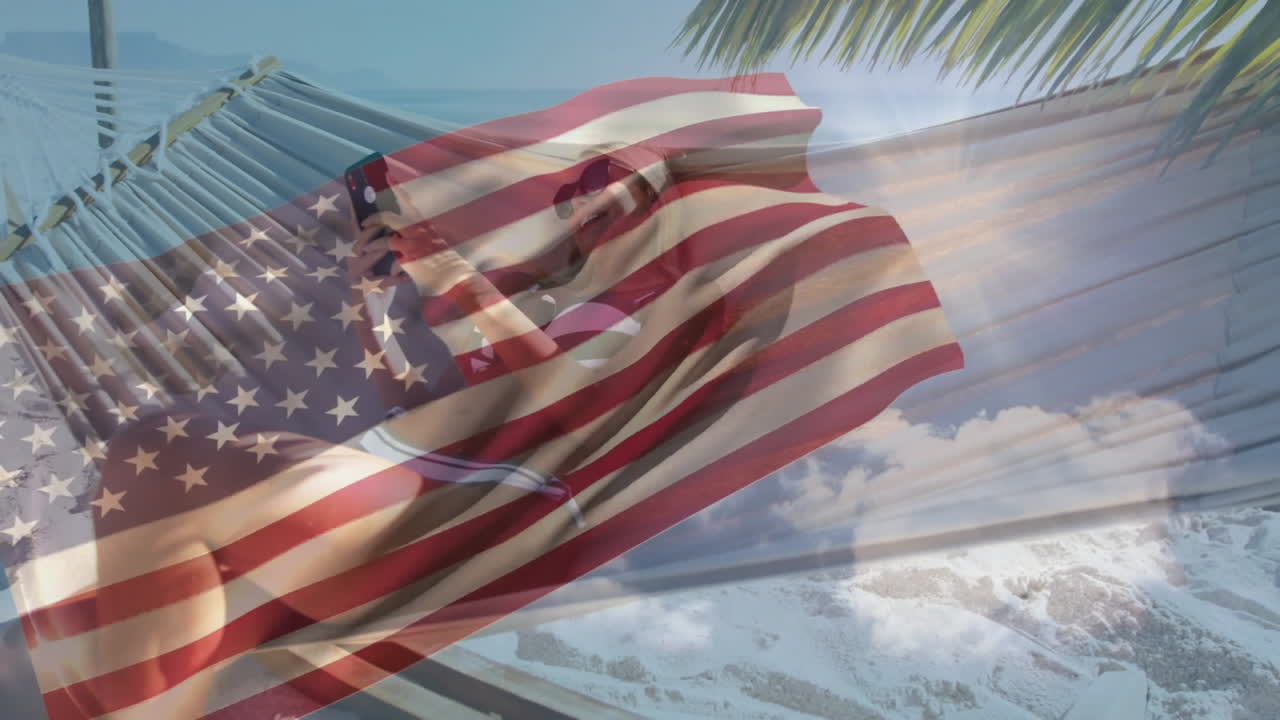 Relaxing in hammock, person with animation of American flag over ocean waves