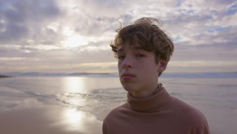 pensive teenager at sunset beach