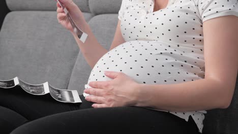 pregnant on sofa with ultrasound photo