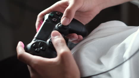 Close-up Gamer&#039;s hands gaming with a black controller