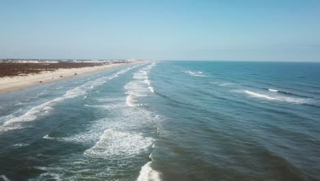 vista aerea del drone parallela alla spiaggia, onde e surf al parco costiero della contea di nueces sull'isola di padre nord texas