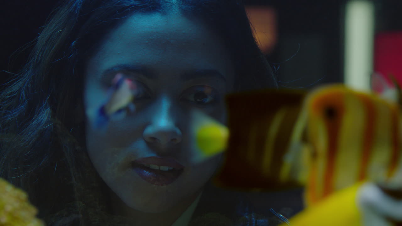 mujer viajera mirando peces tropicales en el tanque del acuario viendo la hermosa vida marina colorida en el hábitat marino