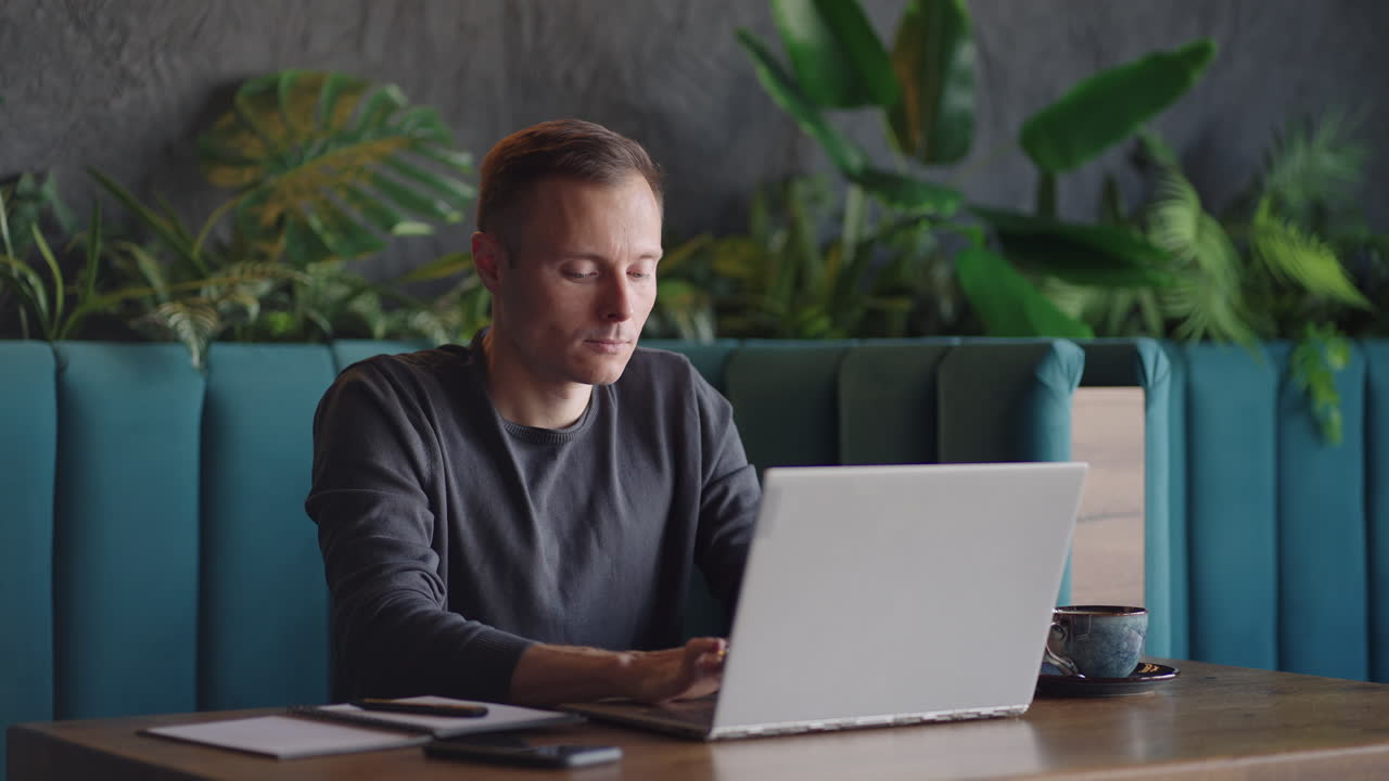 beautiful male developer or student working studying by laptop in cafe. freelance remote work online education self employed