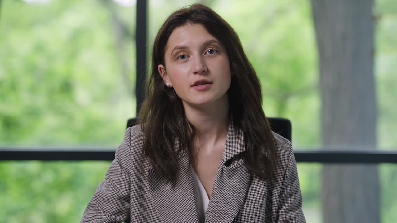 Portrait of confident woman talking in video chat looking at camera. Front view of professional Caucasian female manager brainstorming online with colleagues on lockdown remote working.