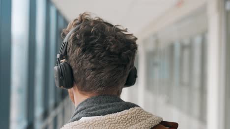 close-up view of the back of a man's head in headphones