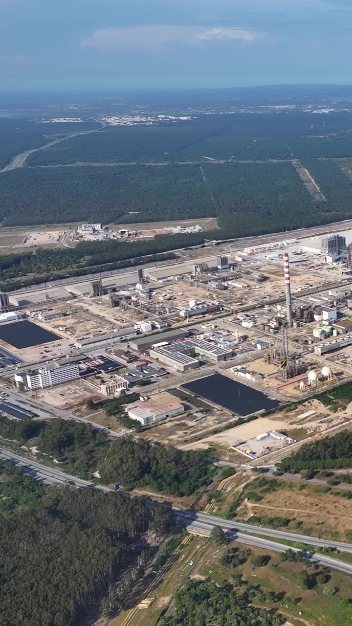 Footage shows an oil refinery complex with various processing units and infrastructure. The aerial view captures the operational layout and activity at the site.