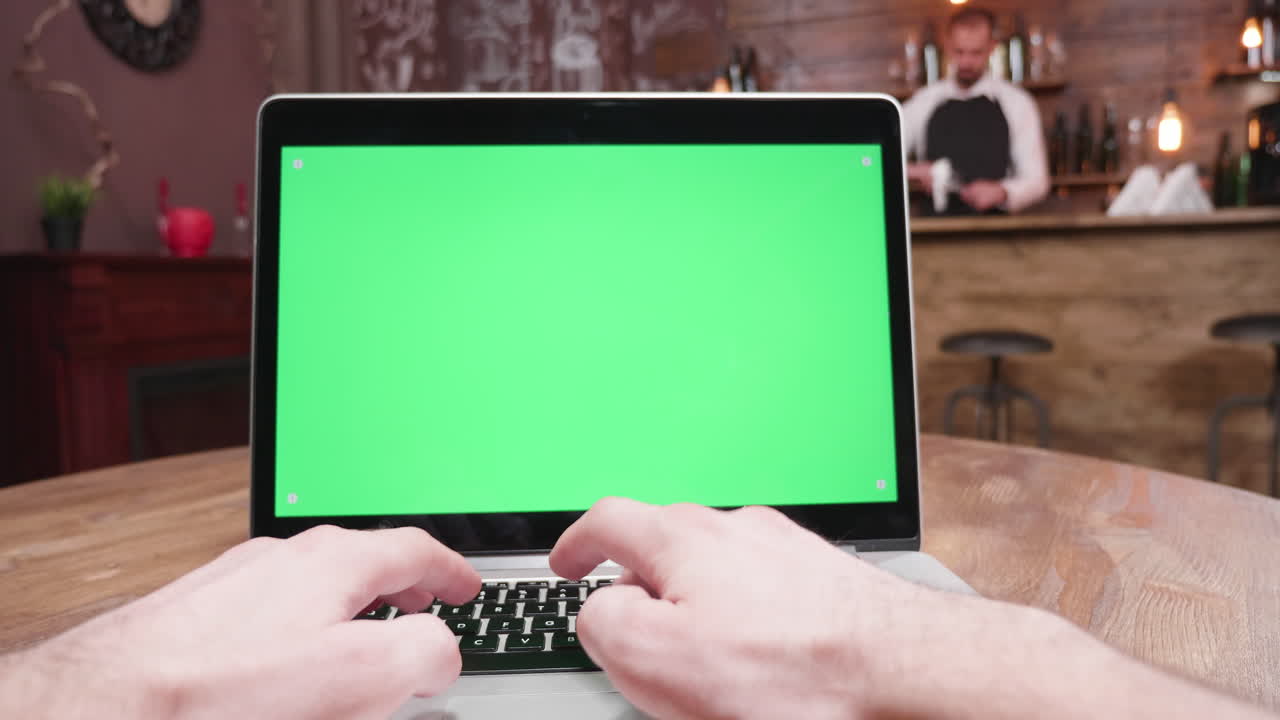 Laptop with green screen in a bar