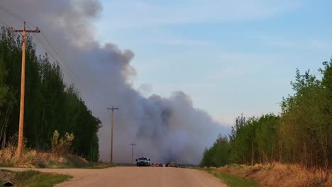 Driving-on-Dirt-Road-Toward-Smoke-Filled-Sky-from-Forest-Fires-in-Alberta,-Canada