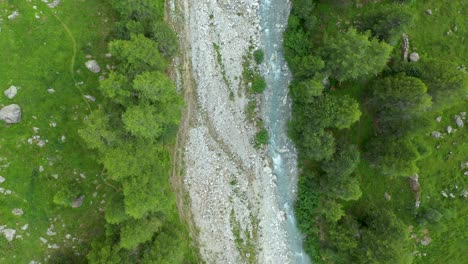 Vuelo-De-Drones-Sobre-Un-Sinuoso-Río-Glaciar-A-Través-De-Un-Valle-Alpino-De-Alta-Montaña