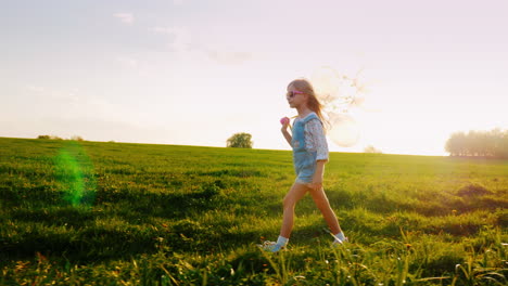 A-Cool-Girl-In-Pink-Sunglasses-Walks-Through-The-Green-Meadow-At-Sunset