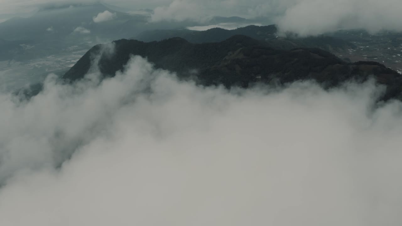 산과 함께 아름다운 풍경을 드러내는 구름 위로 높이 날아가는 드론 조감도