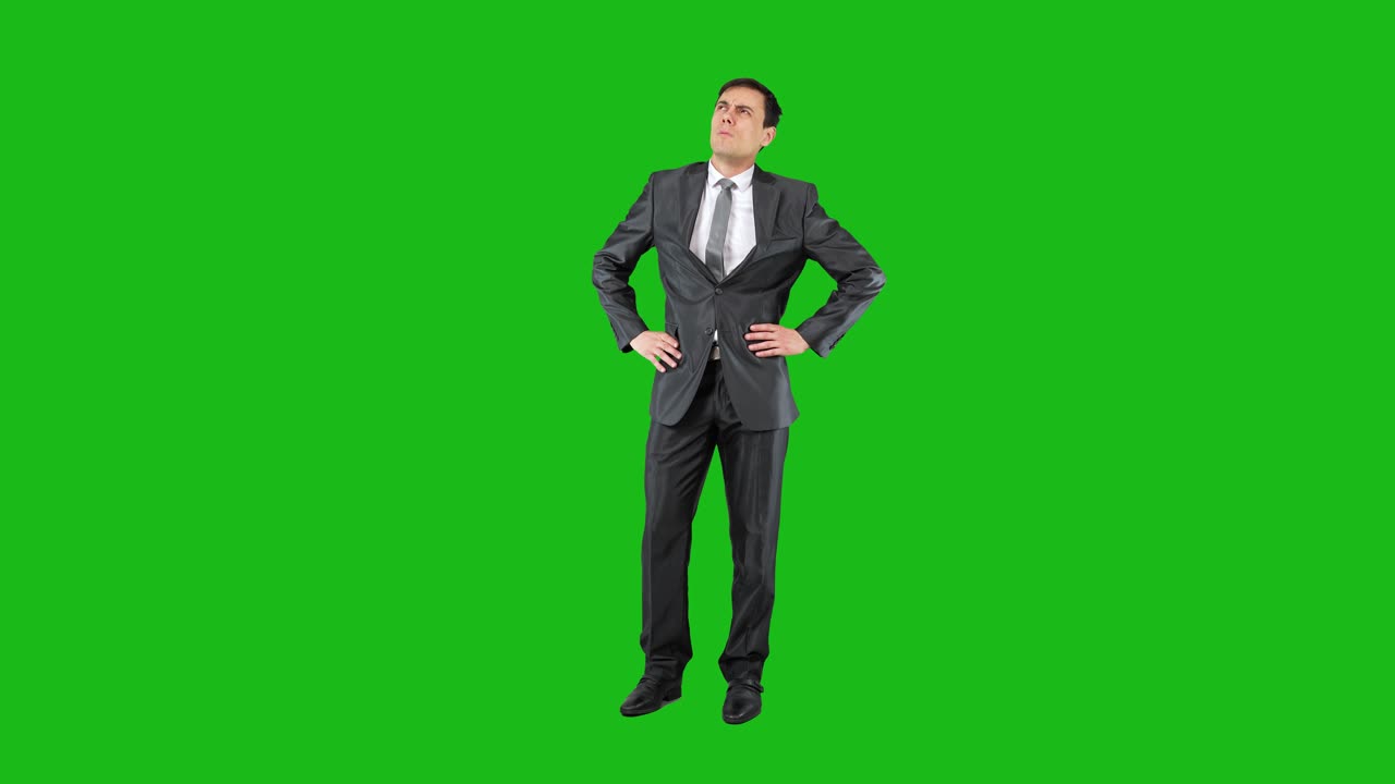 Businessman Looking Up with Hands on Hips on Green Screen