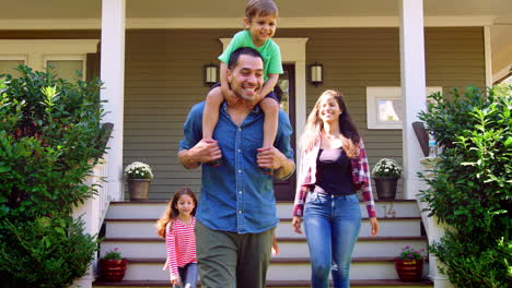 el padre le da a su hijo un paseo en los hombros mientras la familia sale de la casa.