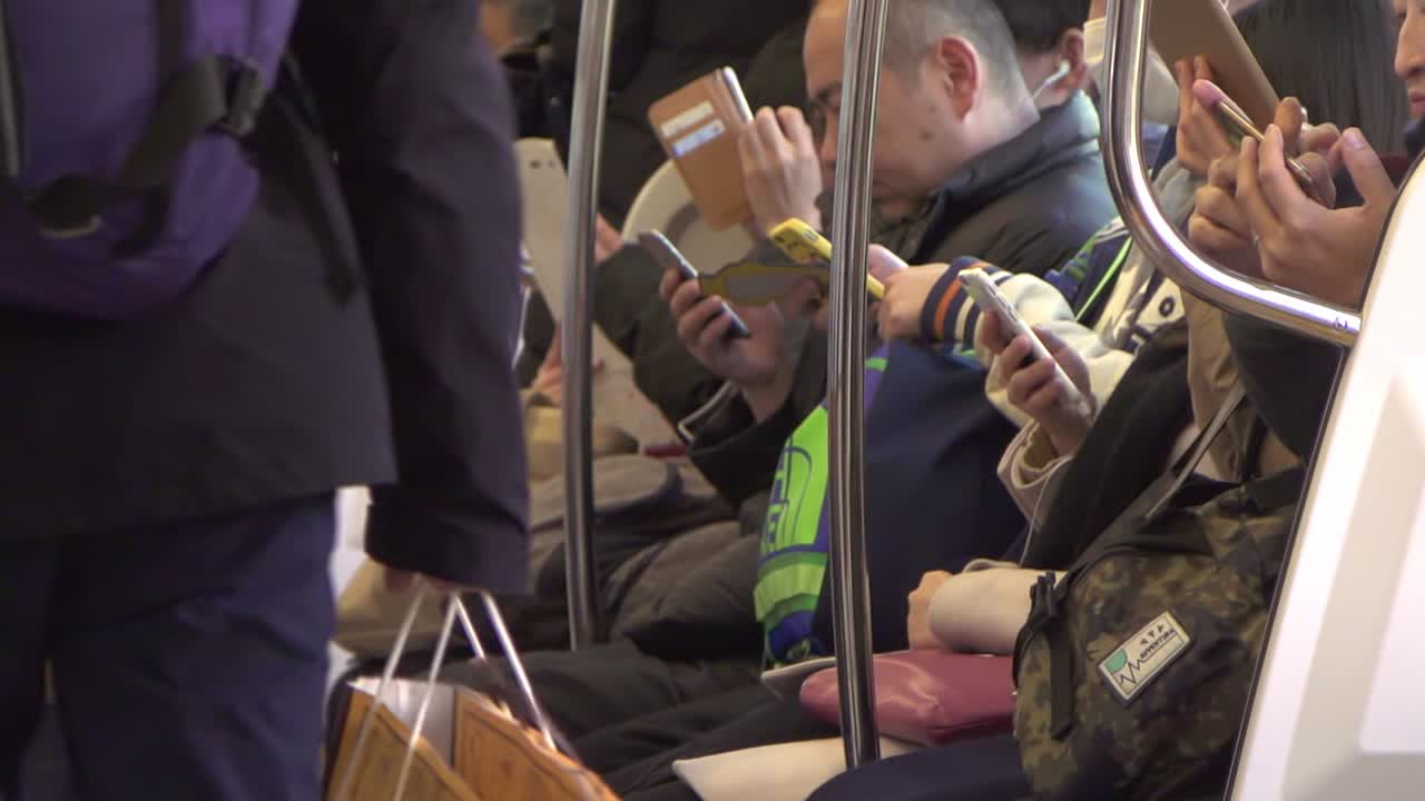 스마트폰을 사용하는 통근자